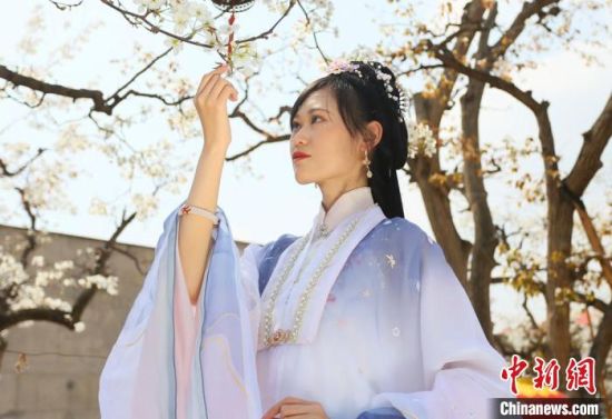 圖為蘭州青年身穿漢服在百年梨園賞景?！「哒?攝