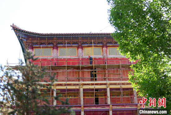圖為5月上旬，甘肅山丹縣大佛寺內(nèi)，工作人員對(duì)古建筑大雄寶殿進(jìn)行修繕。 中新社記者 高展 攝
