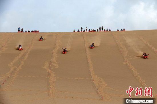6月13日，敦煌鳴沙山月牙泉景區(qū)舉辦滑沙比賽。　張曉亮 攝