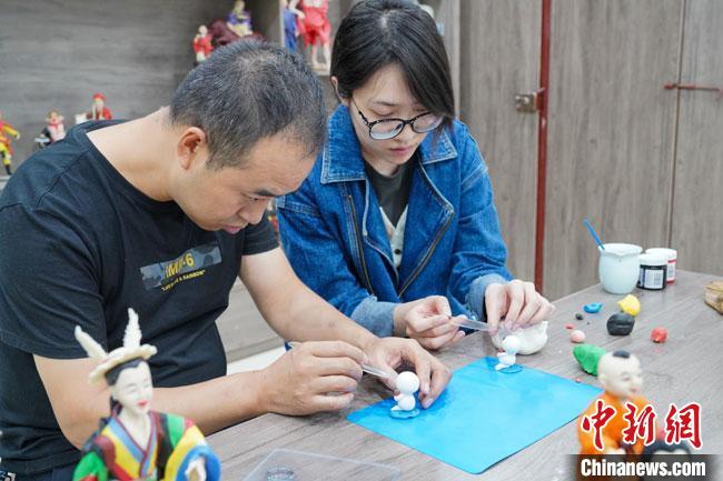 <a target='_blank'  data-cke-saved- >中新社</a>記者(右)現(xiàn)場體驗面塑制作過程?！￡悹帍?攝