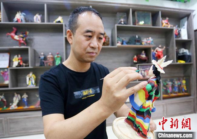 圖為安秋平正在創(chuàng)作代表隴南文縣民俗的《白馬人》作品?！「哒?攝