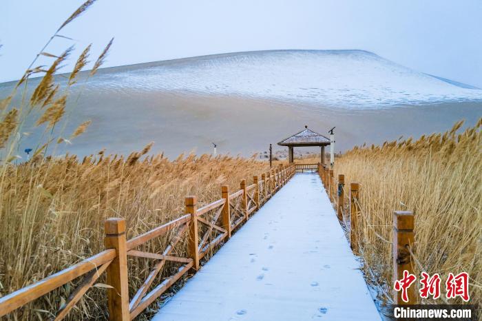 2021年11月28日，在敦煌鳴沙山月牙泉景區(qū)，沙雪交融，更顯北國風(fēng)情?！⊥醣筱y 攝