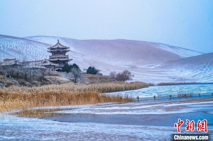 2021年11月28日，雪落鳴沙山月牙泉景區(qū)?！⊥醣筱y 攝