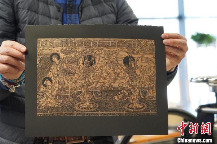圖為手工書藝人展示敦煌雕版壁畫印刷品?！【琶赖┰?　攝