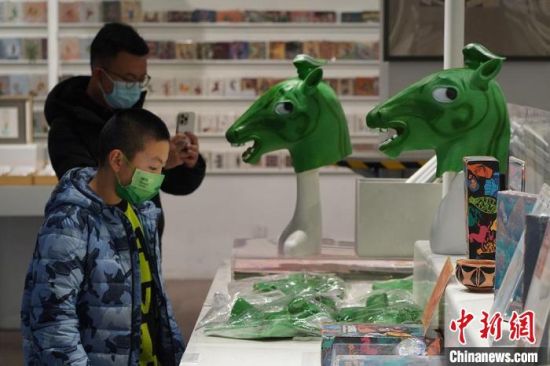 圖為“神馬來了”銅奔馬頭套吸引參觀者駐足?！【琶赖┰?攝
