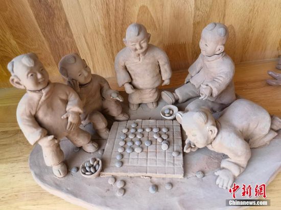 圖為泥塑作品展現(xiàn)下棋場景。 劉玉桃 攝