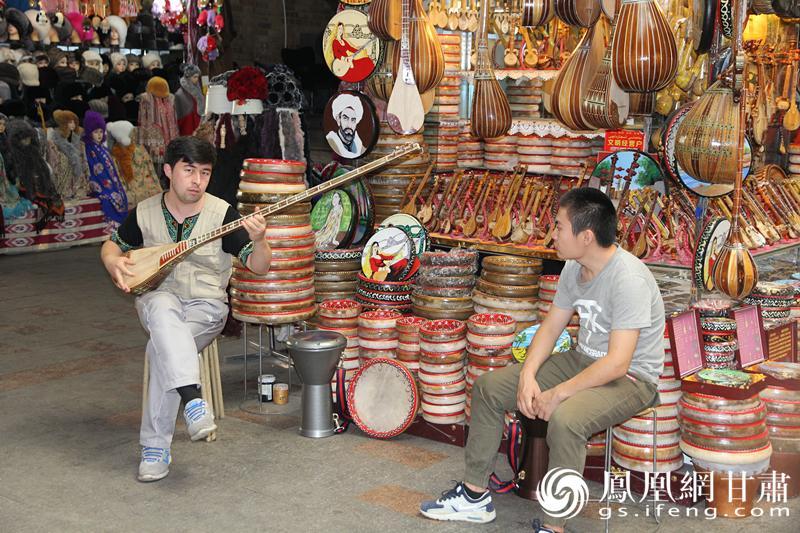 烏魯木齊二道橋巴扎內，店主正在向客人展示樂器。楊文遠 攝