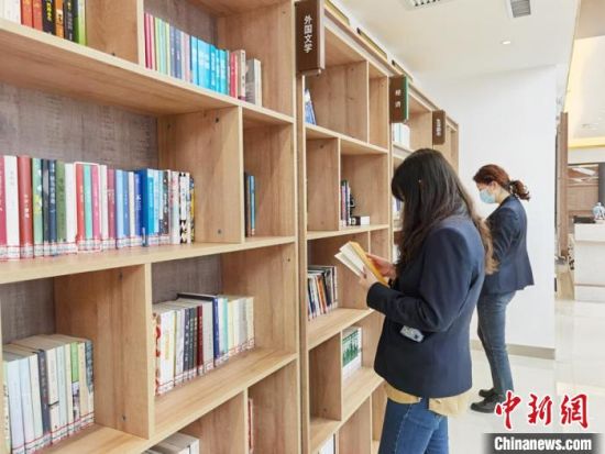 圖為在甘肅公航旅建設(shè)集團有限公司的職工書屋，職工挑選書籍?！⌒煅?攝