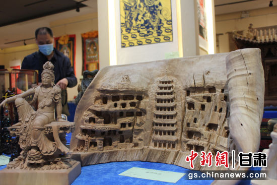 連日來，甘肅省工藝美術(shù)行業(yè)評審認定工作會議在蘭州舉行。圖為以敦煌莫高窟為題材的木雕作品《守護》。徐雪 攝