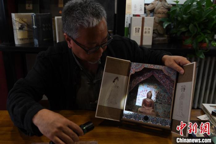 圖為讀者出版集團(tuán)讀者晉林工作室獨(dú)立出品人徐晉林，展示互動(dòng)性強(qiáng)的敦煌題材手工書(shū)。(資料圖) 楊艷敏 攝