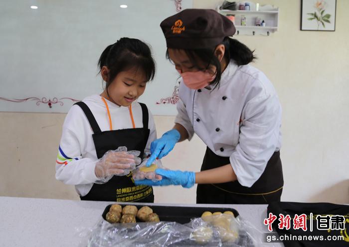 圖為在甘臺胞小朋友在工作人員指導下制作月餅。九美旦增 攝