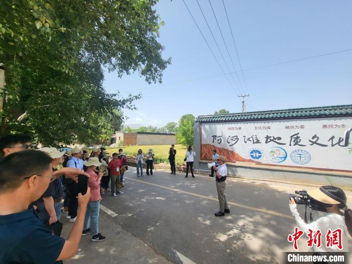 圖為中國(guó)地質(zhì)大學(xué)(北京)教授張緒教介紹村落情況?！『衍?攝