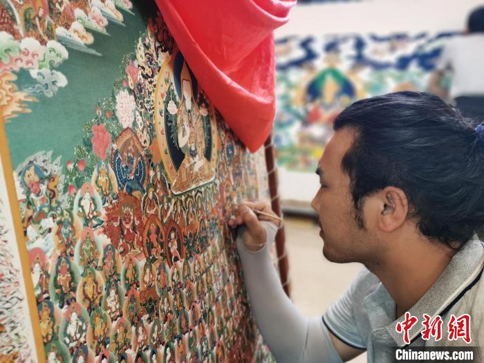 圖為更登才讓的徒弟繪畫唐卡?！?zhí)砀?攝