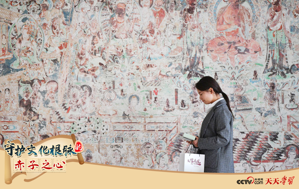 2023年4月25日，敦煌研究院文物數(shù)字化保護(hù)團(tuán)隊(duì)創(chuàng)意營(yíng)銷人員廖雪婷從一幅高保真復(fù)制壁畫前走過。