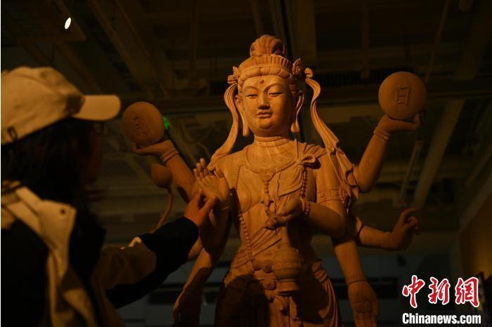 圖為季茂杰觀察自己創(chuàng)作的敦煌木雕。李亞龍 攝</p>
<p>
