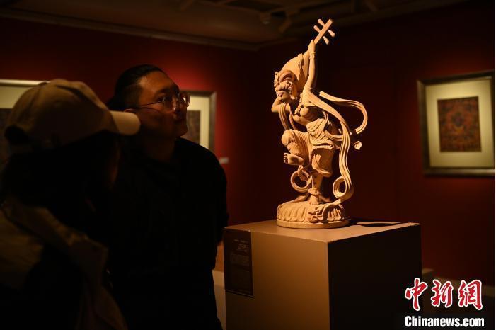 圖為季茂杰向參觀者介紹自己創(chuàng)作敦煌木雕的過程。李亞龍 攝</p>
<p>