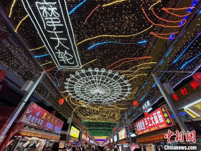 圖為明清街夜市燈光點(diǎn)亮具有武威文化元素的“摩天輪”彩燈?！〈魑牟?攝</p><p>