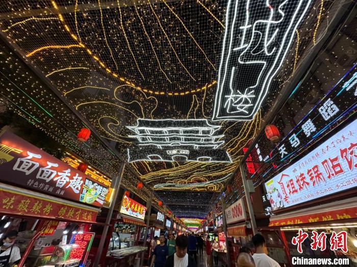 圖為明清街夜市燈光點(diǎn)亮具有武威文化元素的“涼州古城門”彩燈?！〈魑牟?攝</p><p>